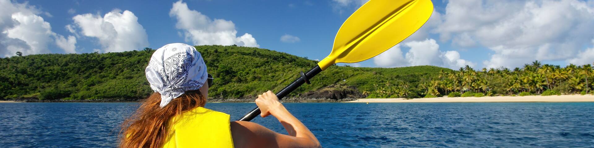 Young woman kayaking near Drawaqa Island in Yasawas, Fiji