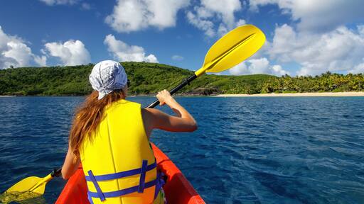 Young woman kayaking near Drawaqa Island in Yasawas, Fiji