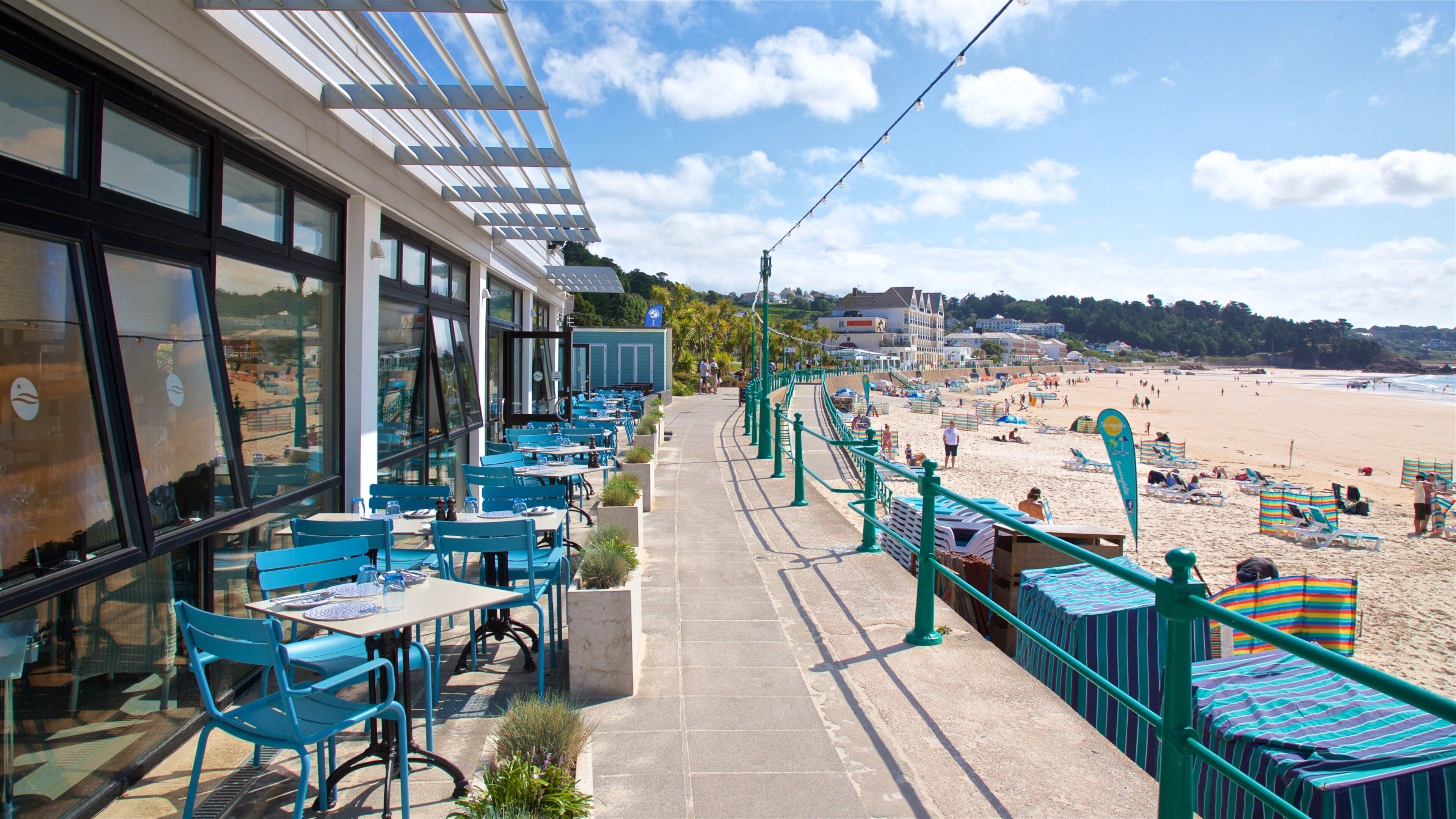 Un restaurante junto a la playa con terraza al aire libre y vistas a la orilla.