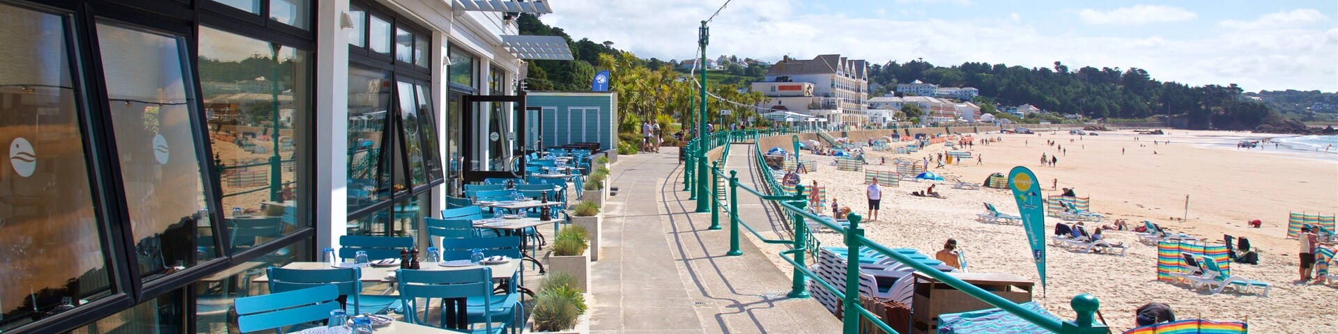 Un restaurante junto a la playa con terraza al aire libre y vistas a la orilla.