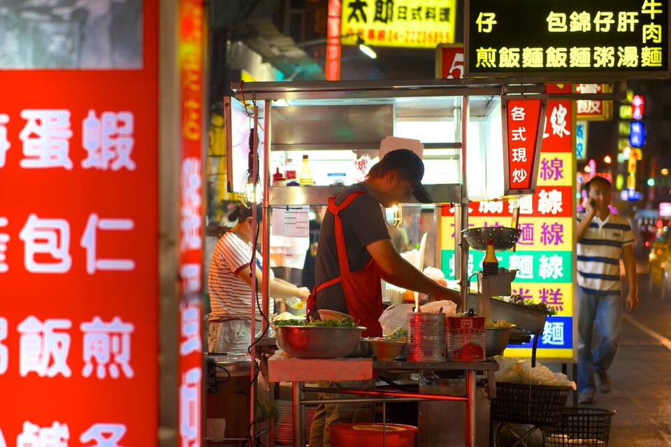 A street food vendor preparing food at night.