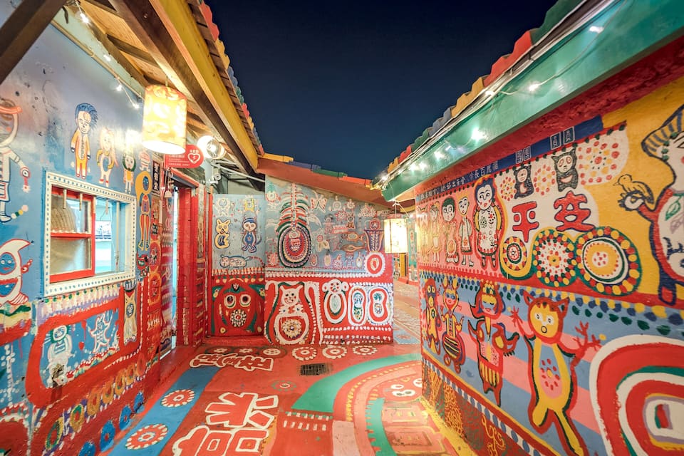 A brightly decorated alleyway with colorful murals and traditional patterns.