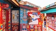 Murales coloridos en la fachada de un edificio, incluyendo una gran representación de un pato y diversos diseños abstractos.
