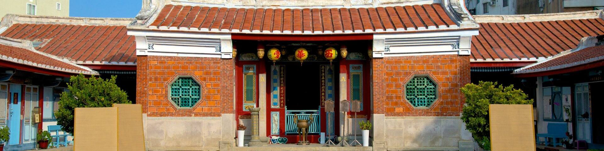 A traditional Chinese gate with red tiles and green decorations.