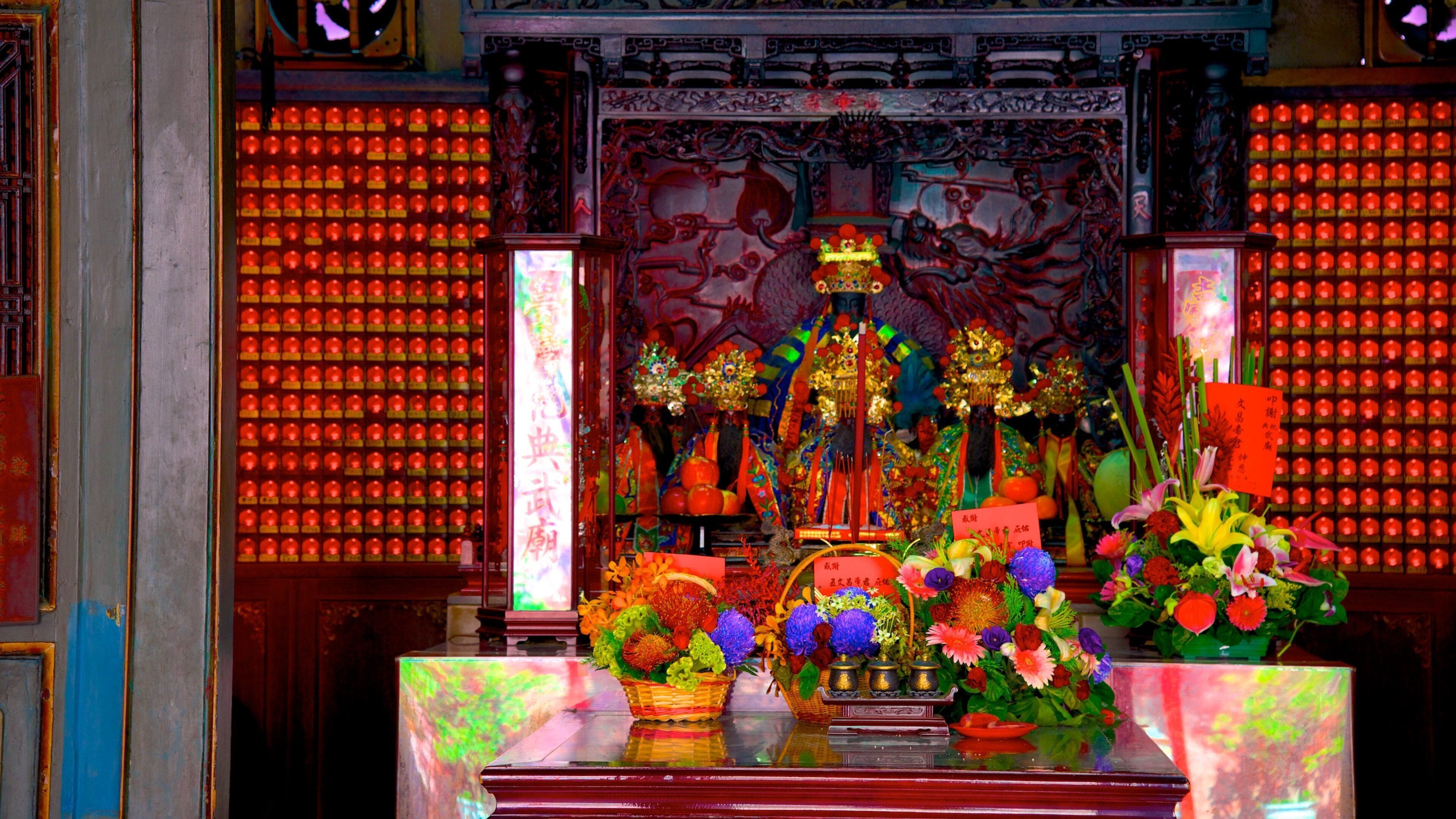 A traditional Chinese altar with intricate decorations, a dragon statue, and offerings of flowers and incense.