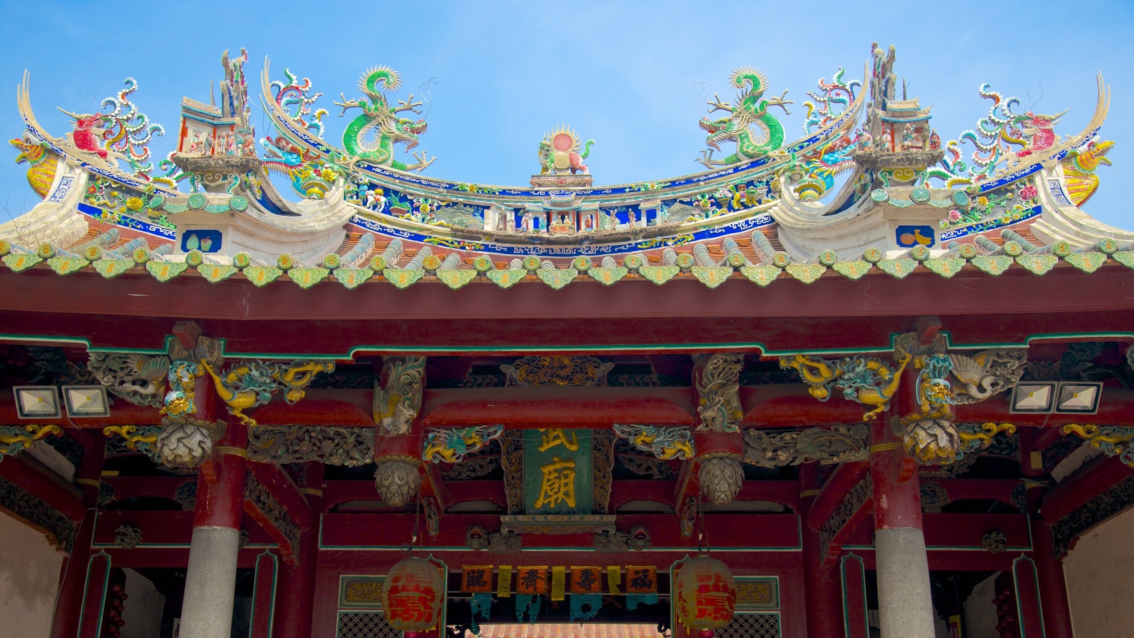 A traditional Chinese temple with ornate dragon decorations and red pillars.