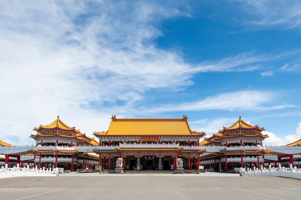 A traditional Chinese temple complex with golden roofs and red pillars.