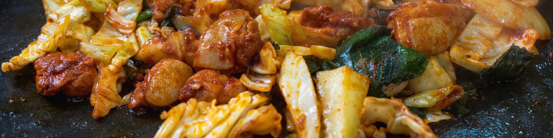 A stir-fried dish with vegetables and meat in a pan.