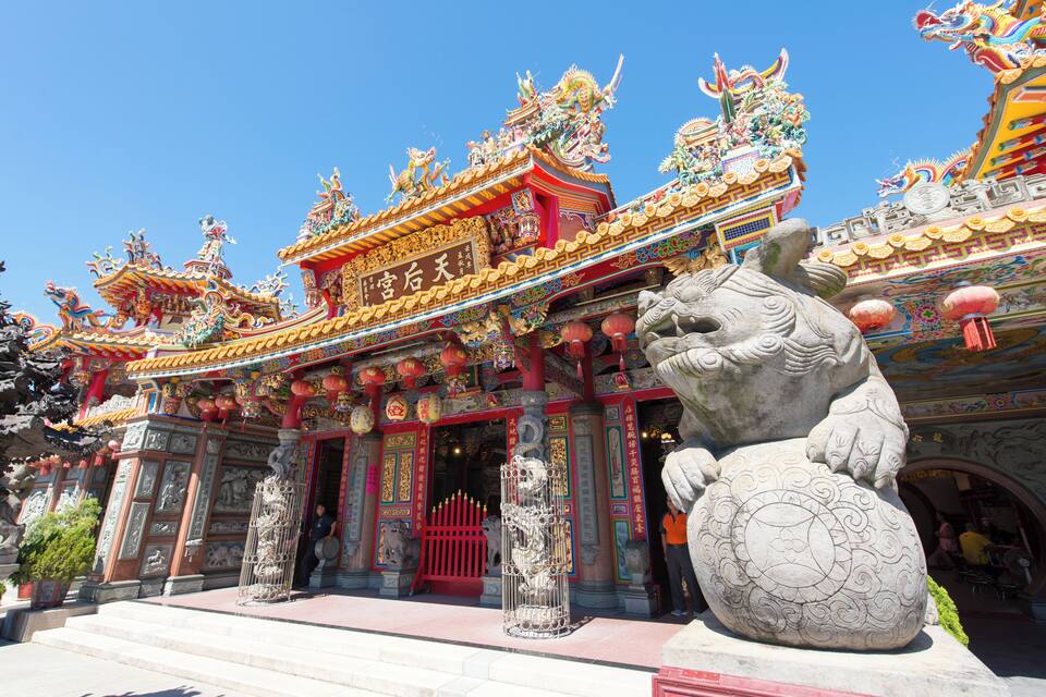 A traditional Chinese temple with ornate architecture, including colorful roofs and statues.