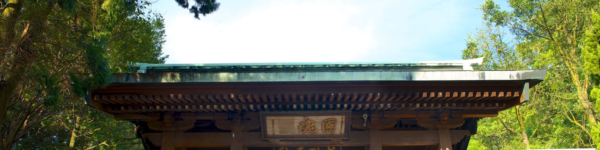 A traditional Japanese torii gate with a wooden structure and a stone staircase leading up to it.