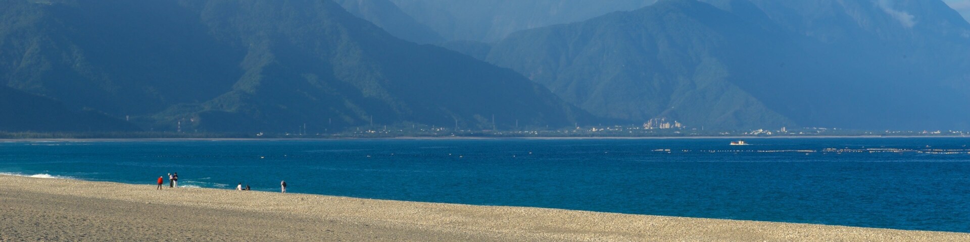 Uma praia com montanhas ao fundo.