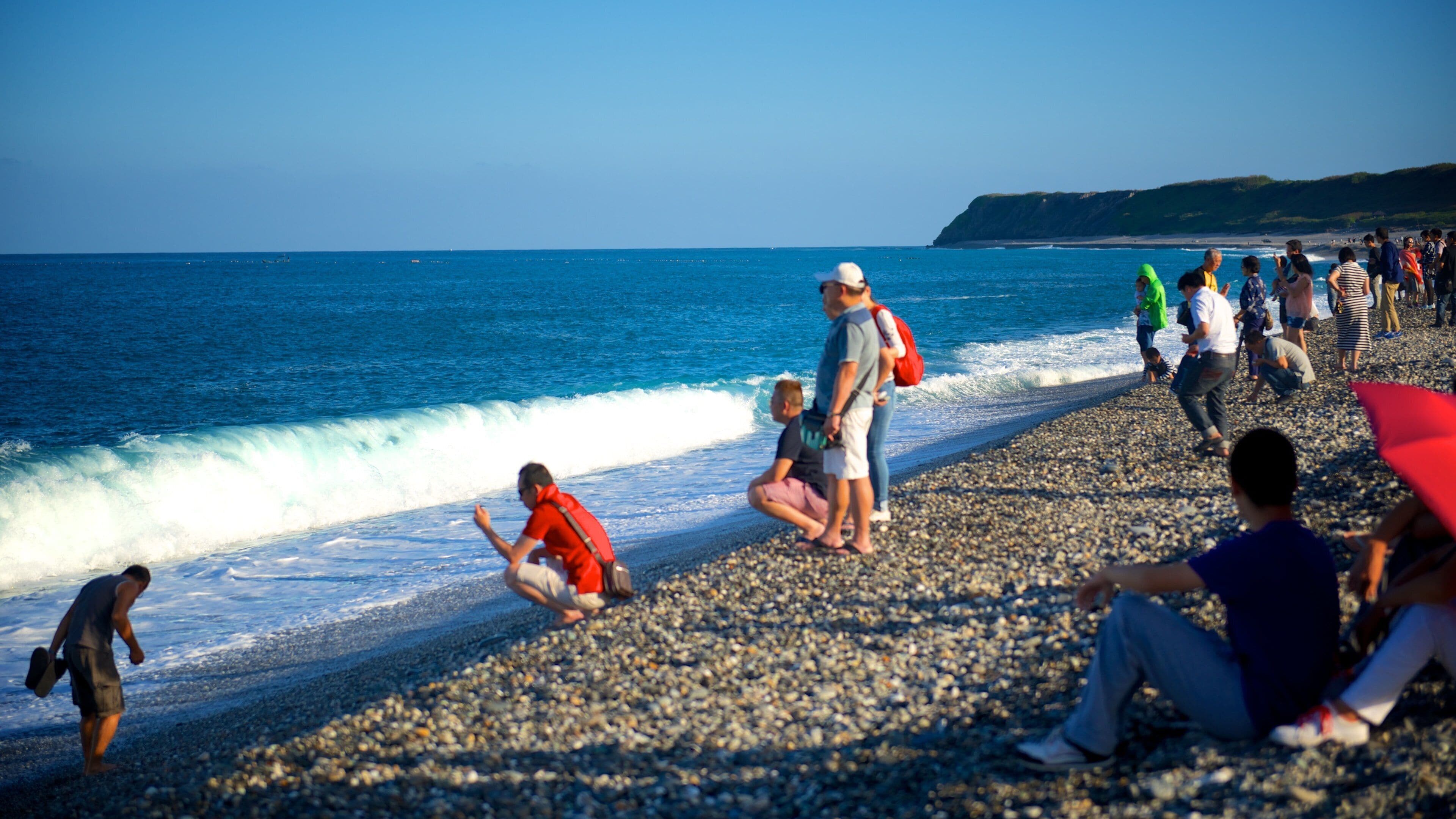 Strand von Chishingtan mit einem Steinstrand sowie kleine Menschengruppe
