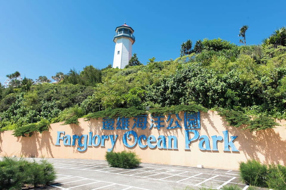 A sign for Fargary Ocean Park with a lighthouse in the background.