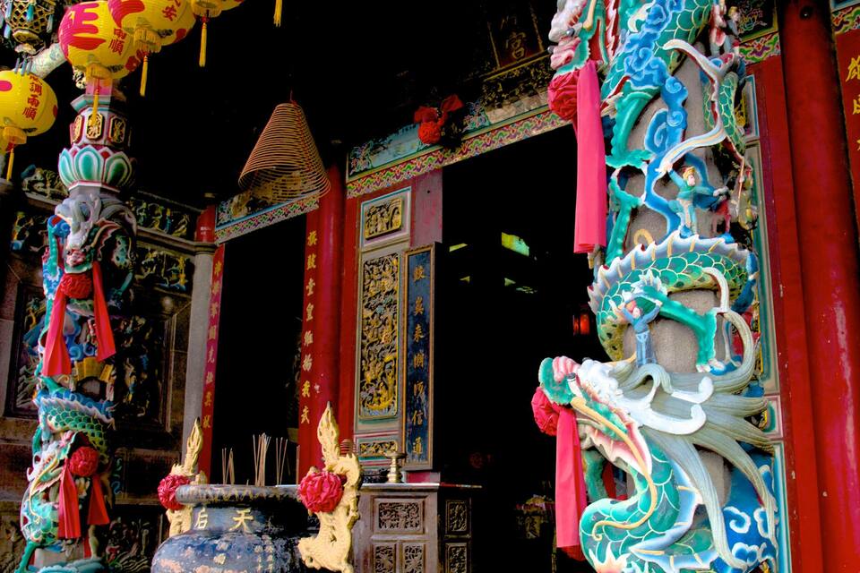 Een traditionele Chinese tempel met gedetailleerde draakbeelden, kleurrijke lantaarns en ingewikkelde muurreliëfs.