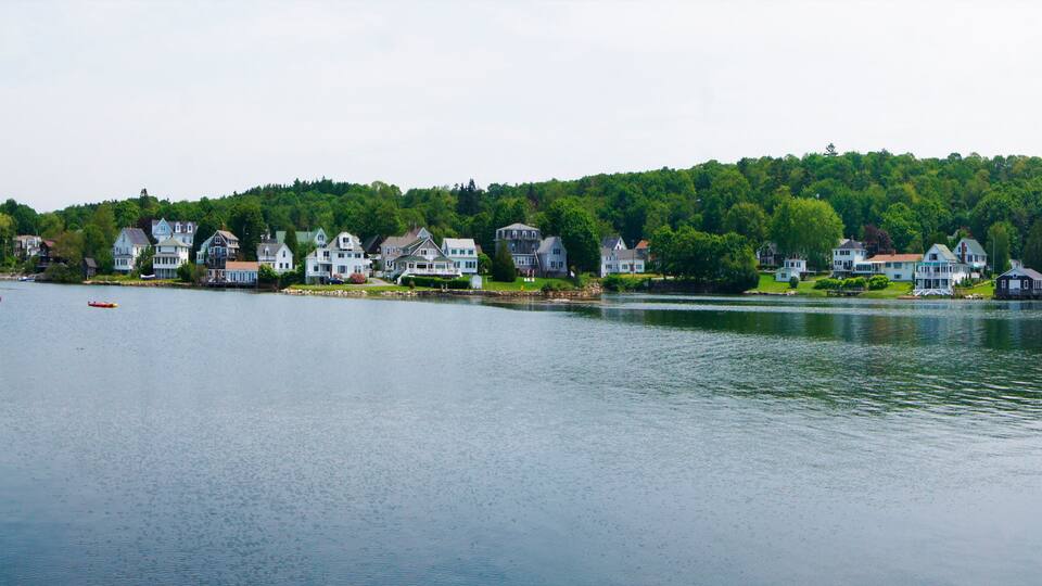 A lakeside town with houses and boats.