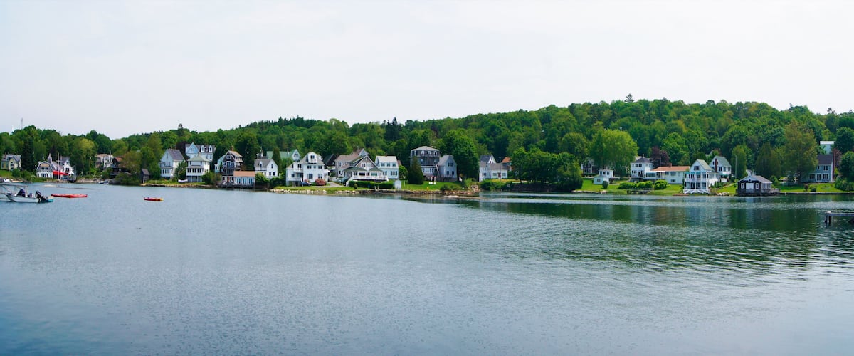 A lakeside town with houses and boats.