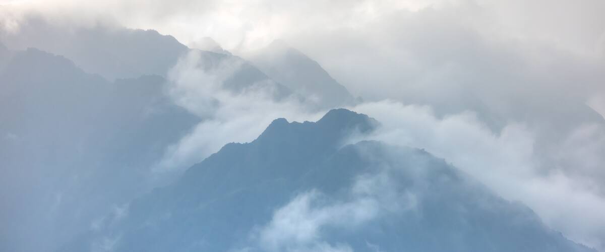 A mountain range partially obscured by clouds.