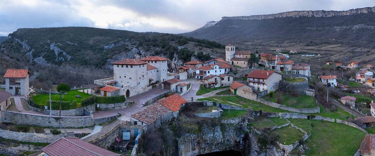 A historic town with stone buildings and a prominent castle on a hillside.