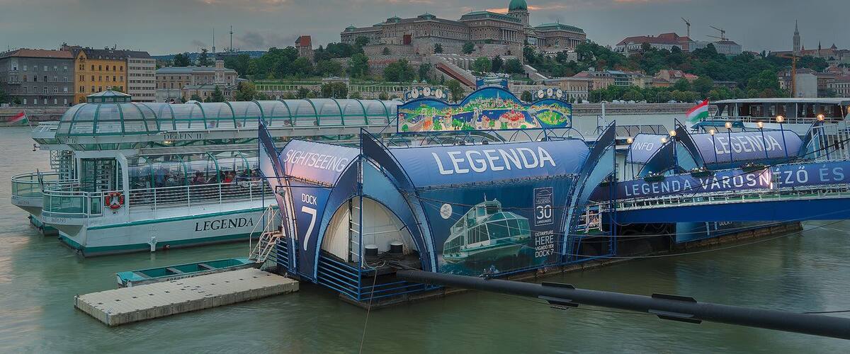 A ferry dock with the name 'LEGEND' and a colorful mural on the side.
