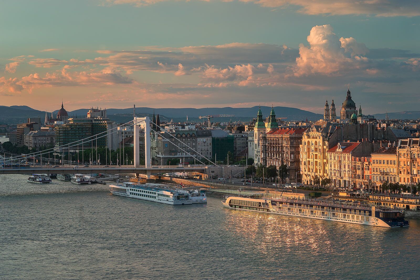A river with boats, a bridge, and historic buildings.