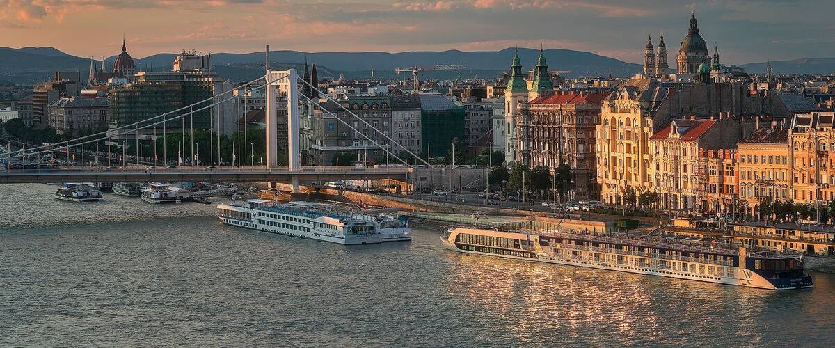 A river with boats, a bridge, and historic buildings.