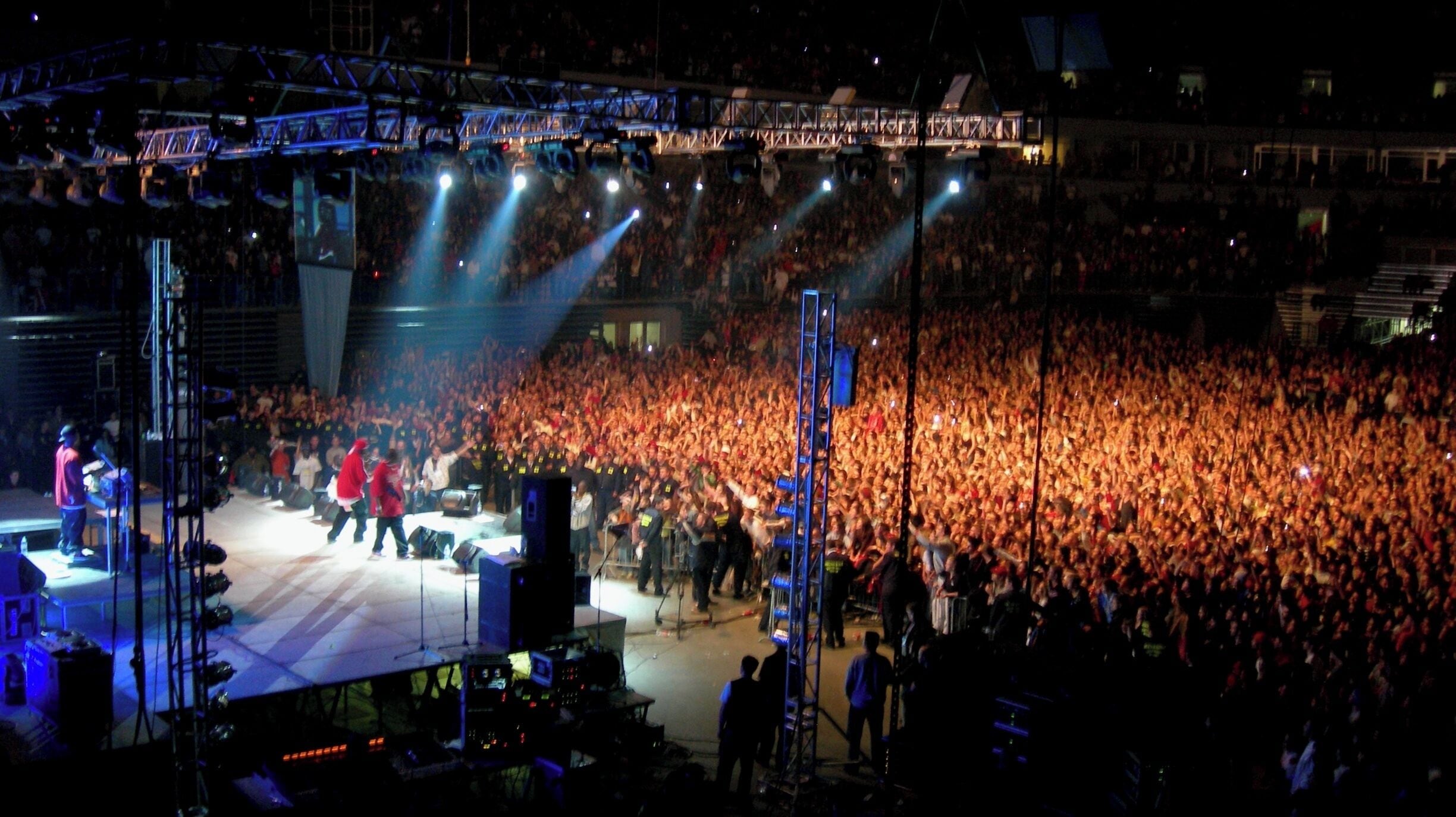 A large outdoor concert with a stage and a crowd of people.