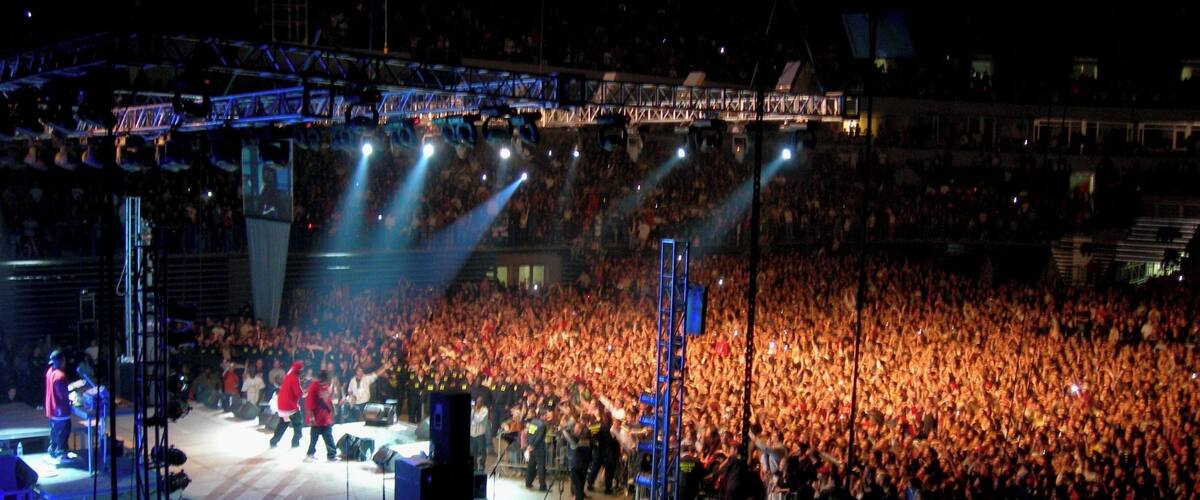 A large outdoor concert with a stage and a crowd of people.