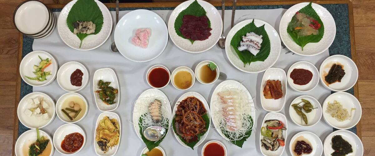 A variety of dishes arranged on a table, including plates with food and condiments.