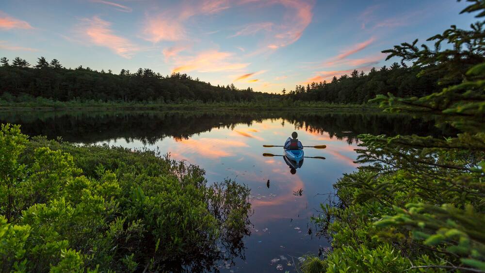 Kayaking a small pond in Barrington, New Hampshire. Sunset.