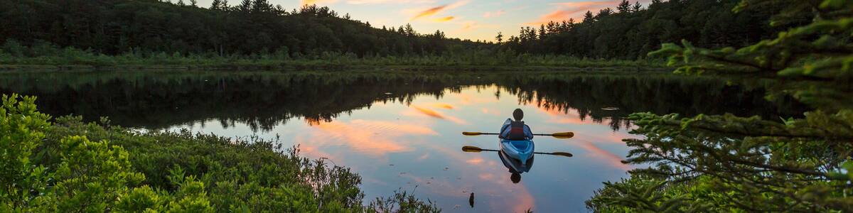 Kayaking a small pond in Barrington, New Hampshire. Sunset.