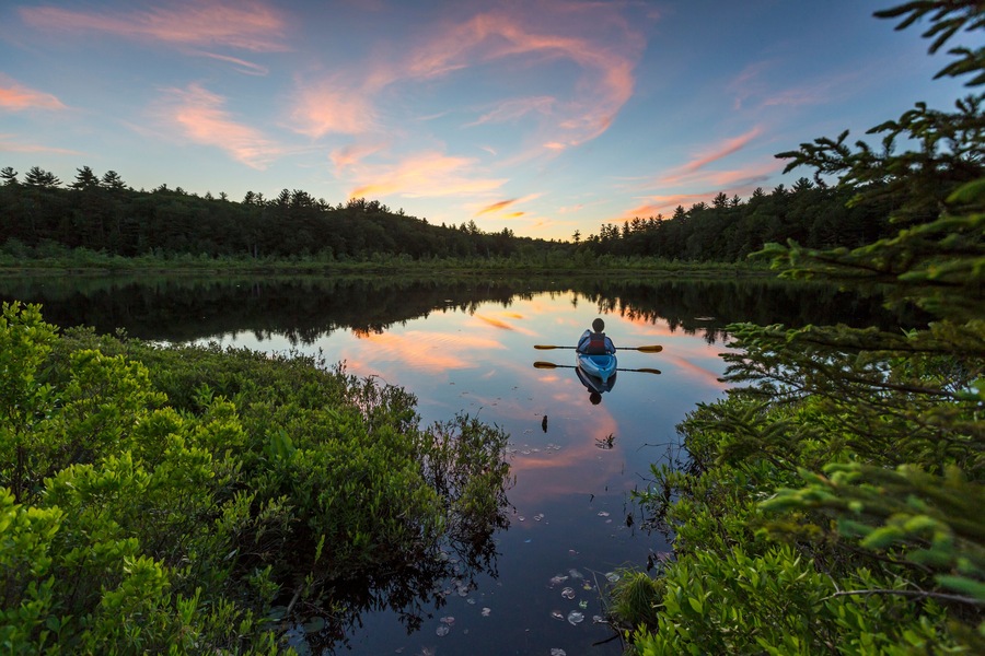 Kayaking a small pond in Barrington, New Hampshire. Sunset.