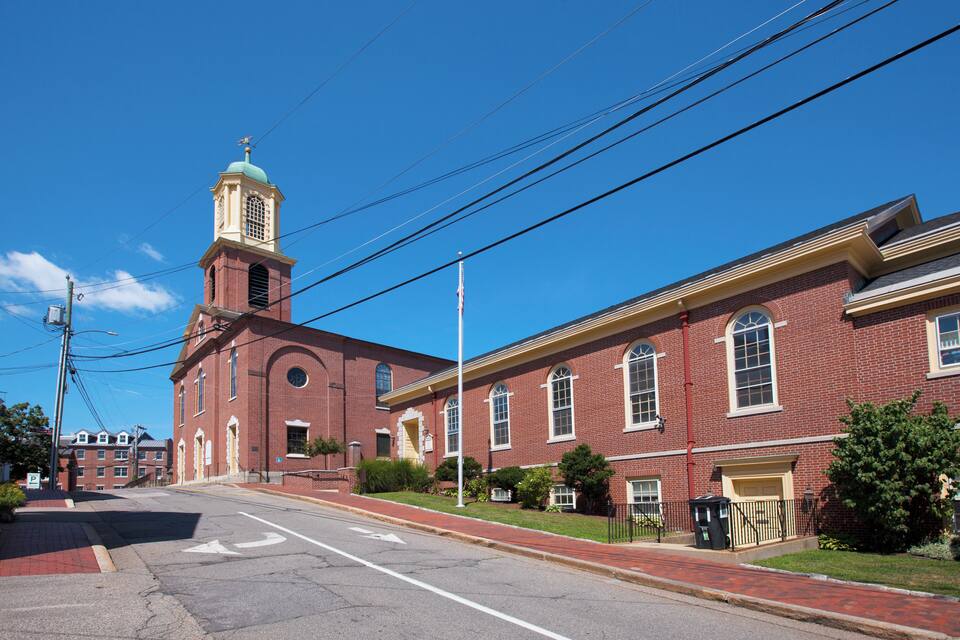 A red brick building with a green dome and a clock tower.
