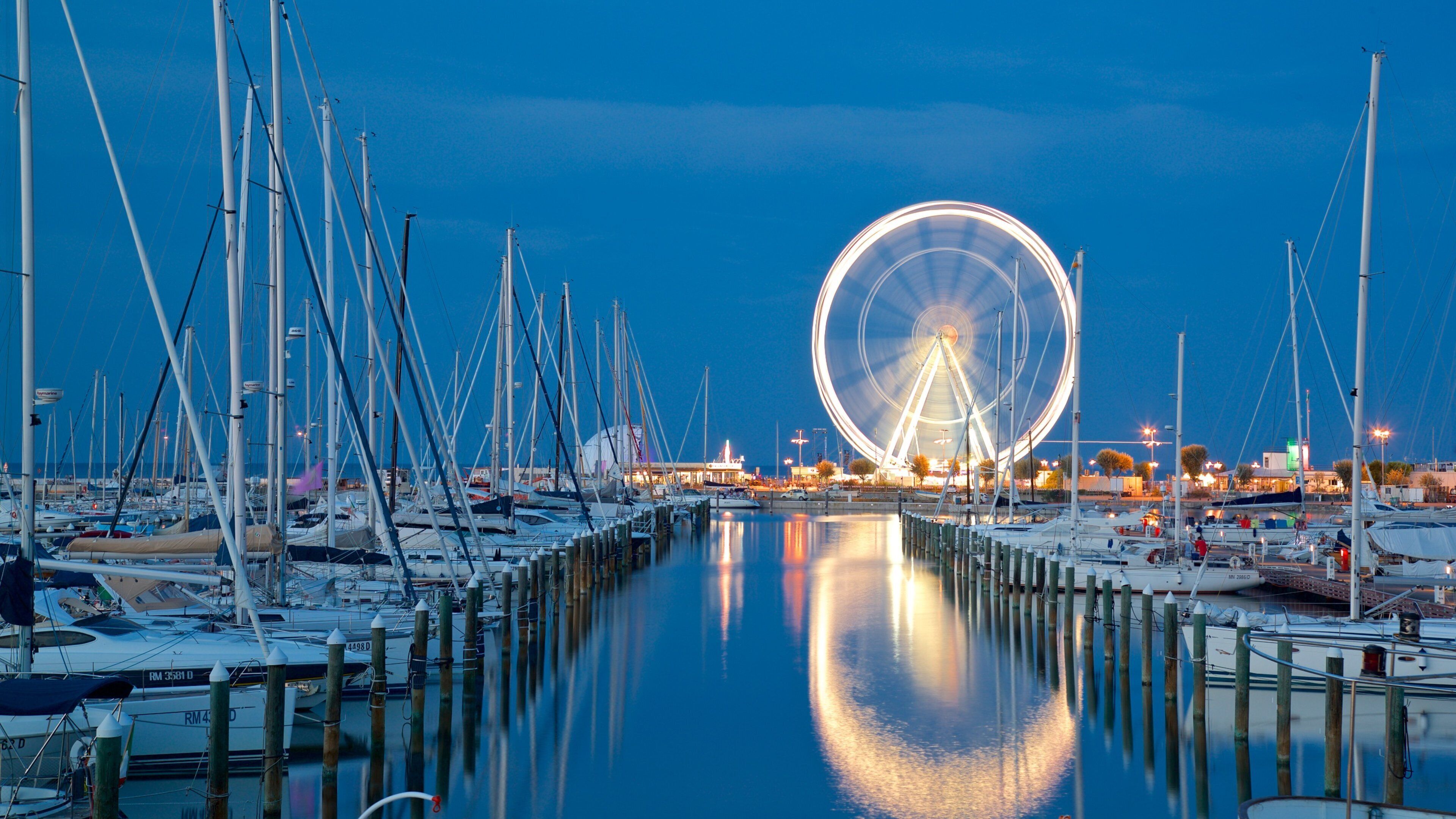 Noria Ferris de Rímini ofreciendo escenas nocturnas y una bahía o puerto