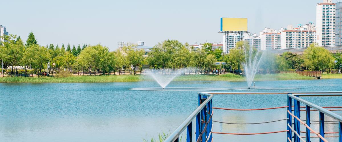 Blue lake and wooden deck walkway in Bucheon Sangdong Lake Park, Korea