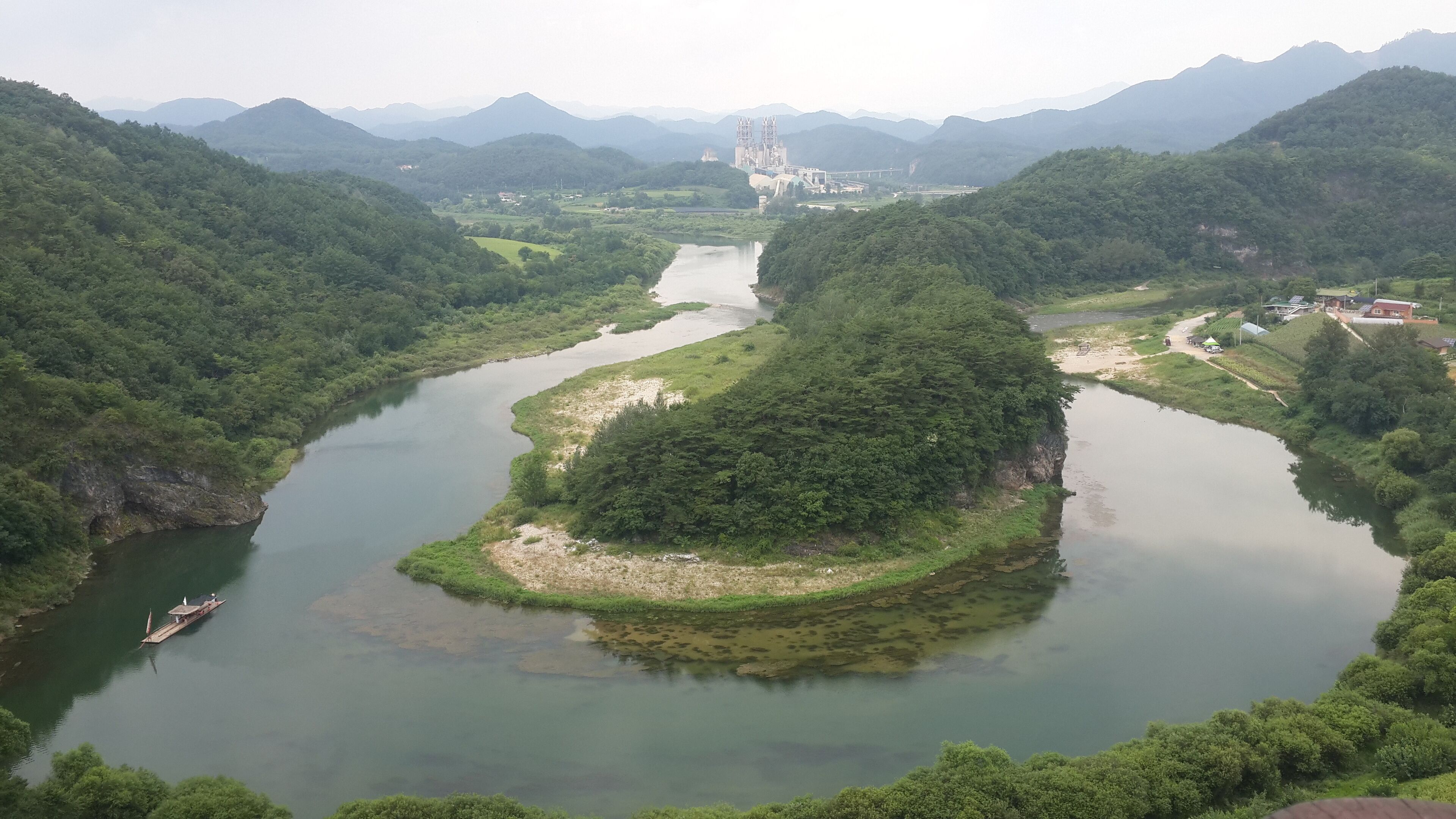 A river winding through a lush valley with mountains in the background.