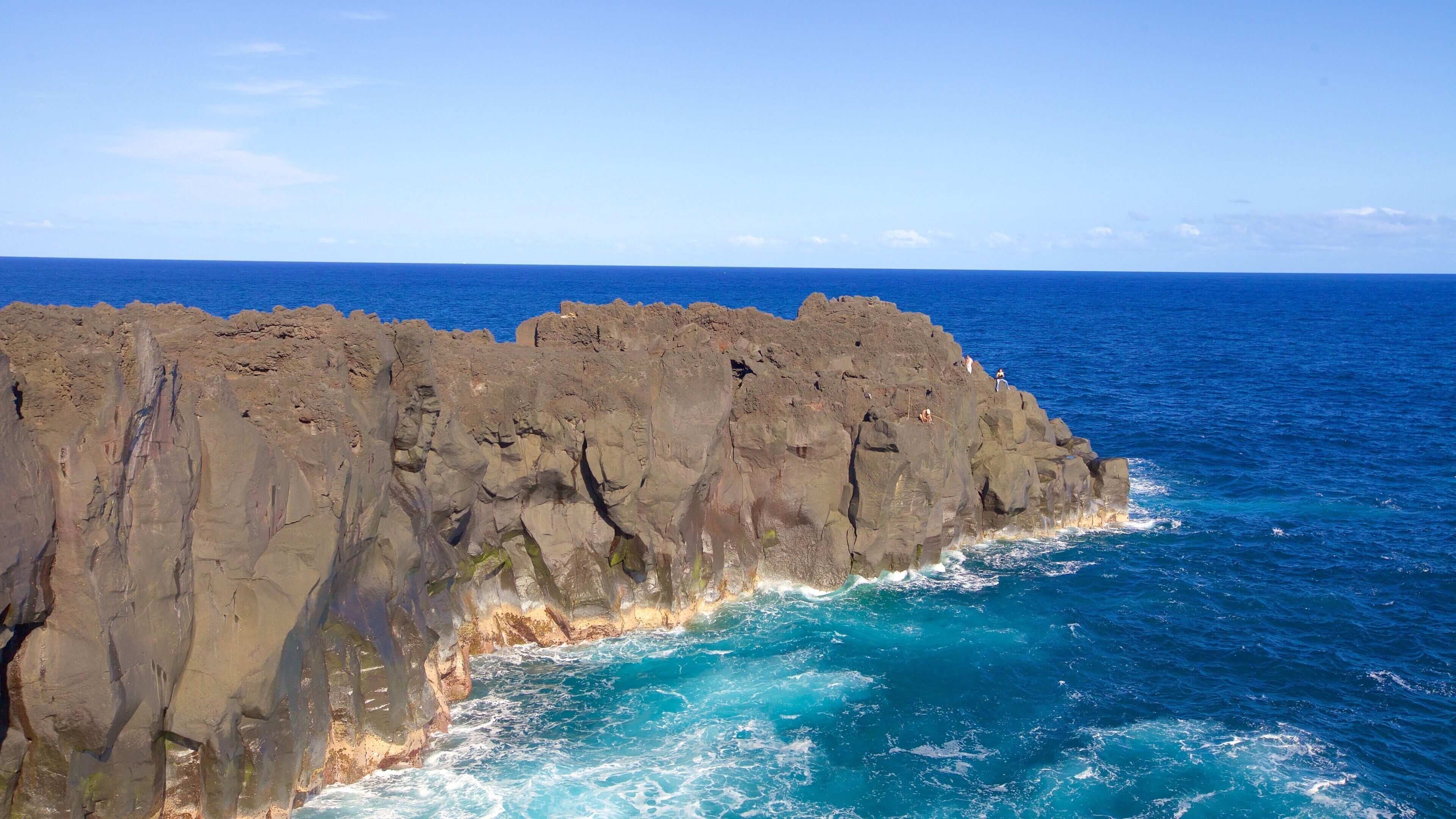 A rocky coastline with waves crashing against the rocks.