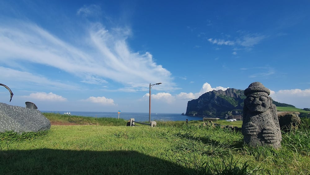 Panoramic view of a Dol hareubang rock statue on Jeju Island, South Korea