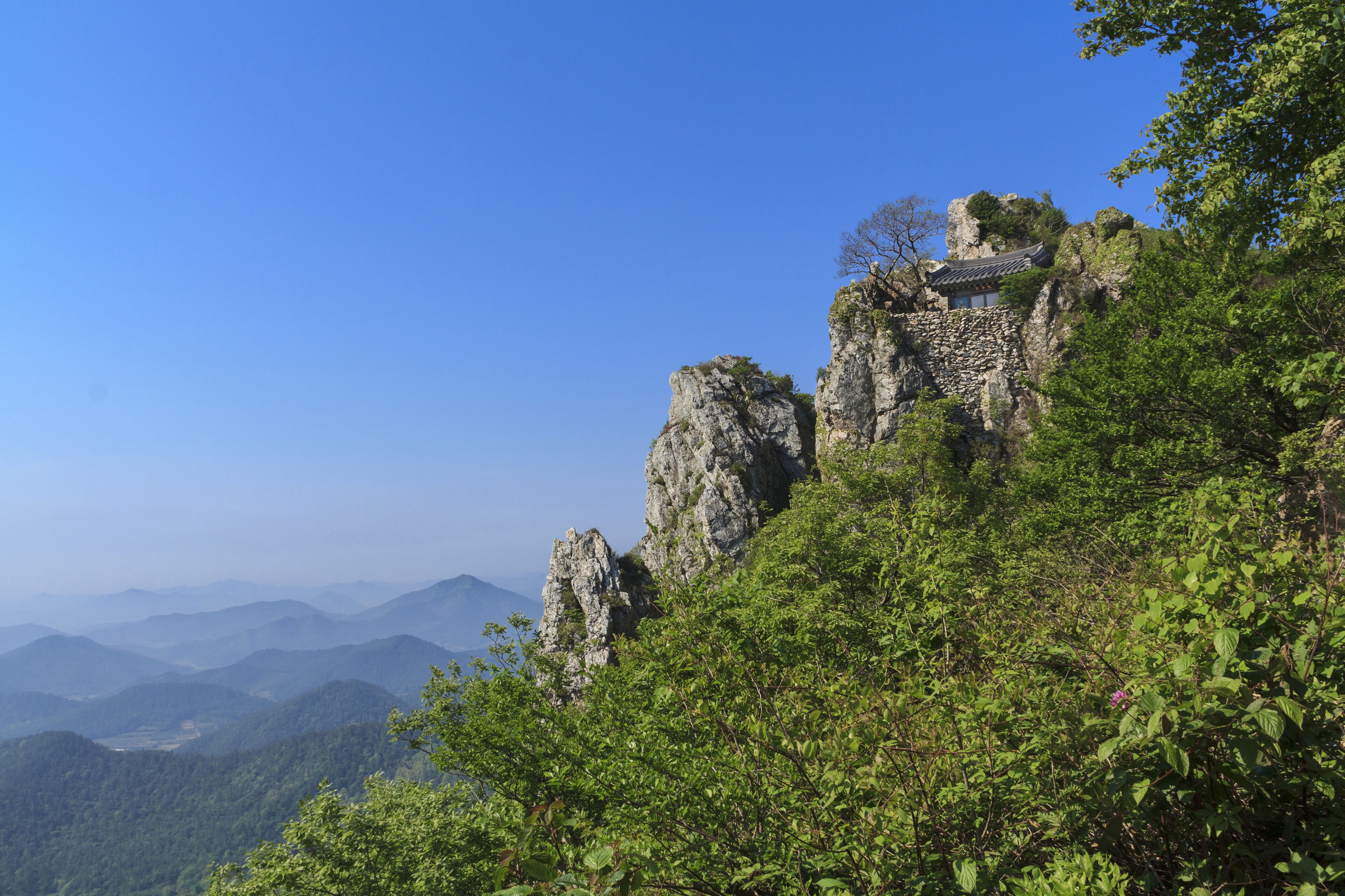 Haenam-gun, Jeollanam-do, South Korea - May 18, 2011: Summer view of green trees and Dosolam Hermitage on rock cliff at Dharma Mountain

