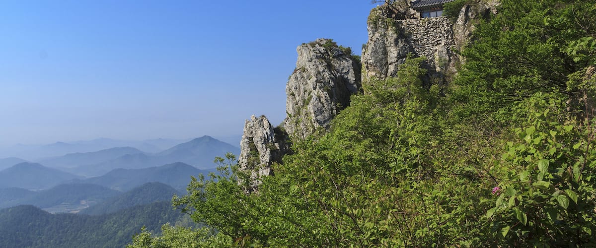 Haenam-gun, Jeollanam-do, South Korea - May 18, 2011: Summer view of green trees and Dosolam Hermitage on rock cliff at Dharma Mountain