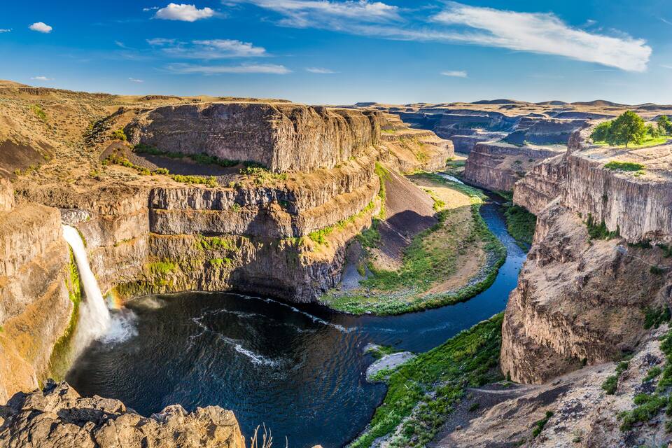 A canyon with a waterfall and a river.