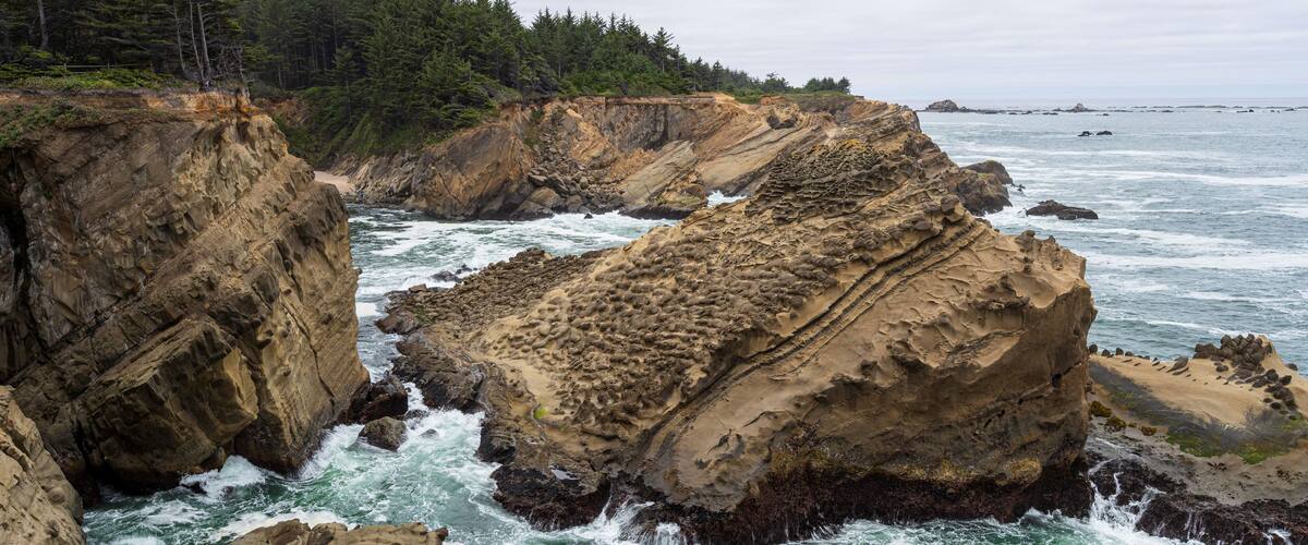 Una costa escarpada con acantilados rocosos y olas oceánicas agitadas.