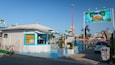 Un quiosco frente al mar con decoración azul y blanca, un tobogán acuático y un letrero que dice Beach Village Riccione.