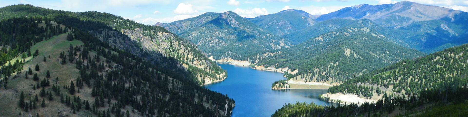 A mountain lake surrounded by forested hills.