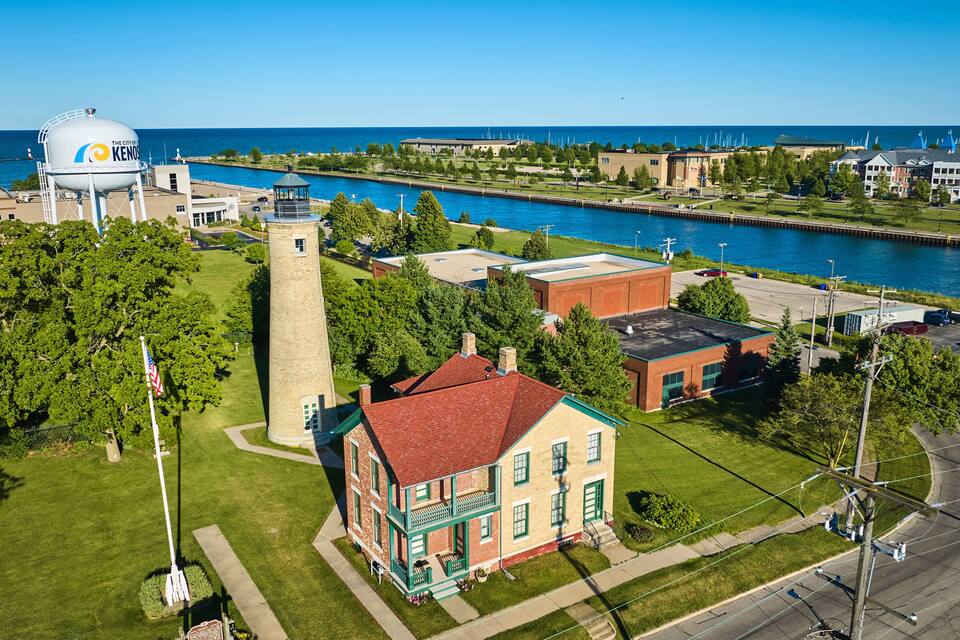 A coastal town with a lighthouse, a water tower, and a historic building.