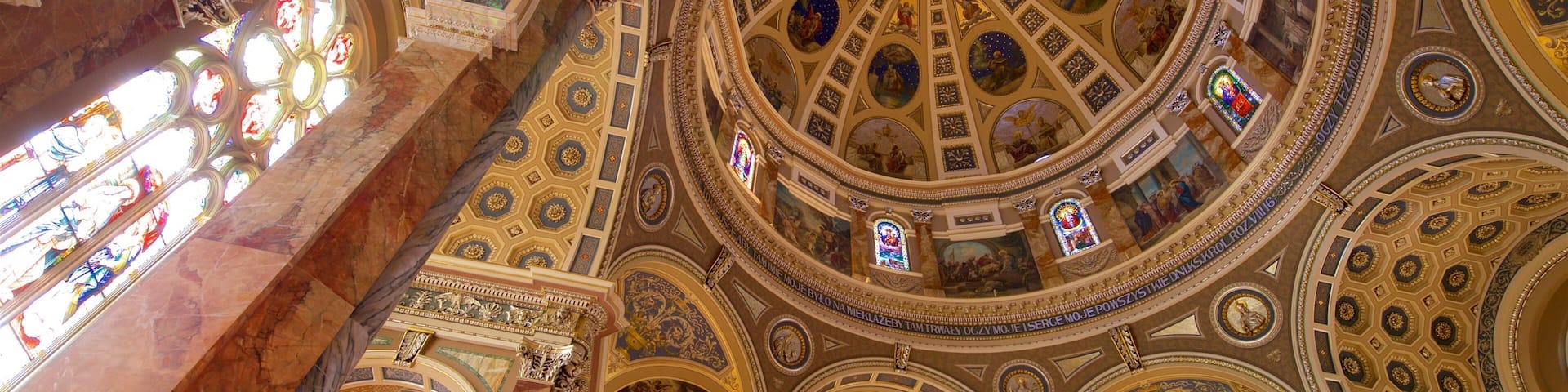 A grand interior with ornate ceilings, intricate frescoes, and stained glass windows.