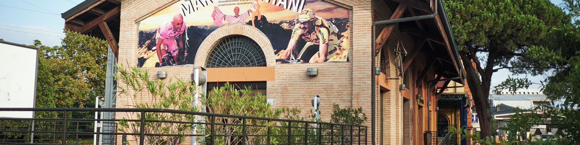 Um edifício com um mural de um homem escalando uma montanha e a inscrição