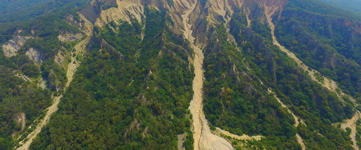 A rugged mountain with steep cliffs and dense forest.