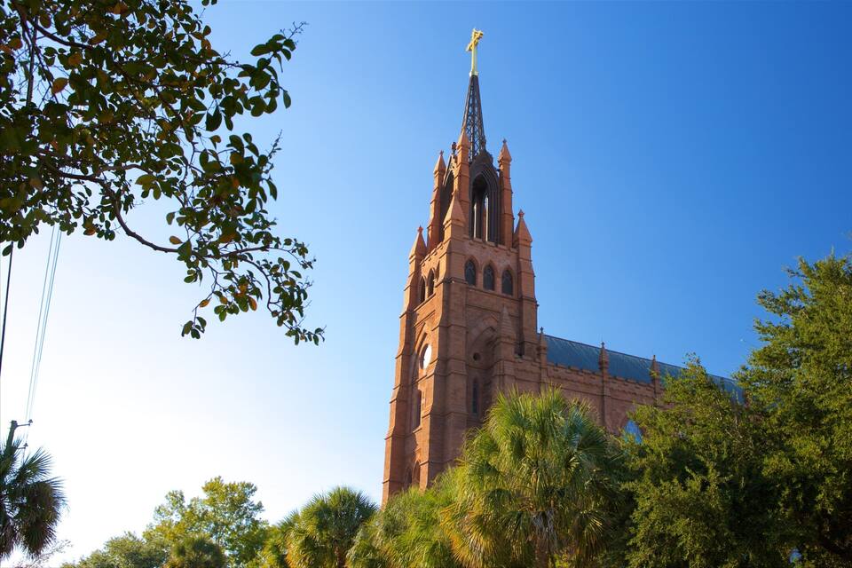 A tall church with a cross on top, surrounded by trees.