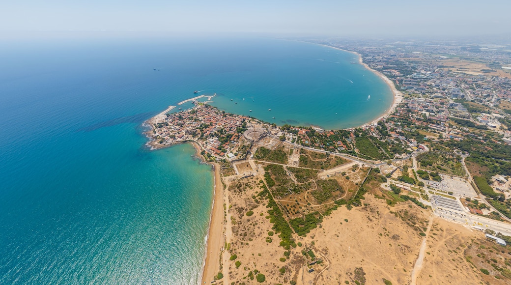 Vista aèria d'una ciutat costanera amb una platja, una badia i zones urbanes circumdants.