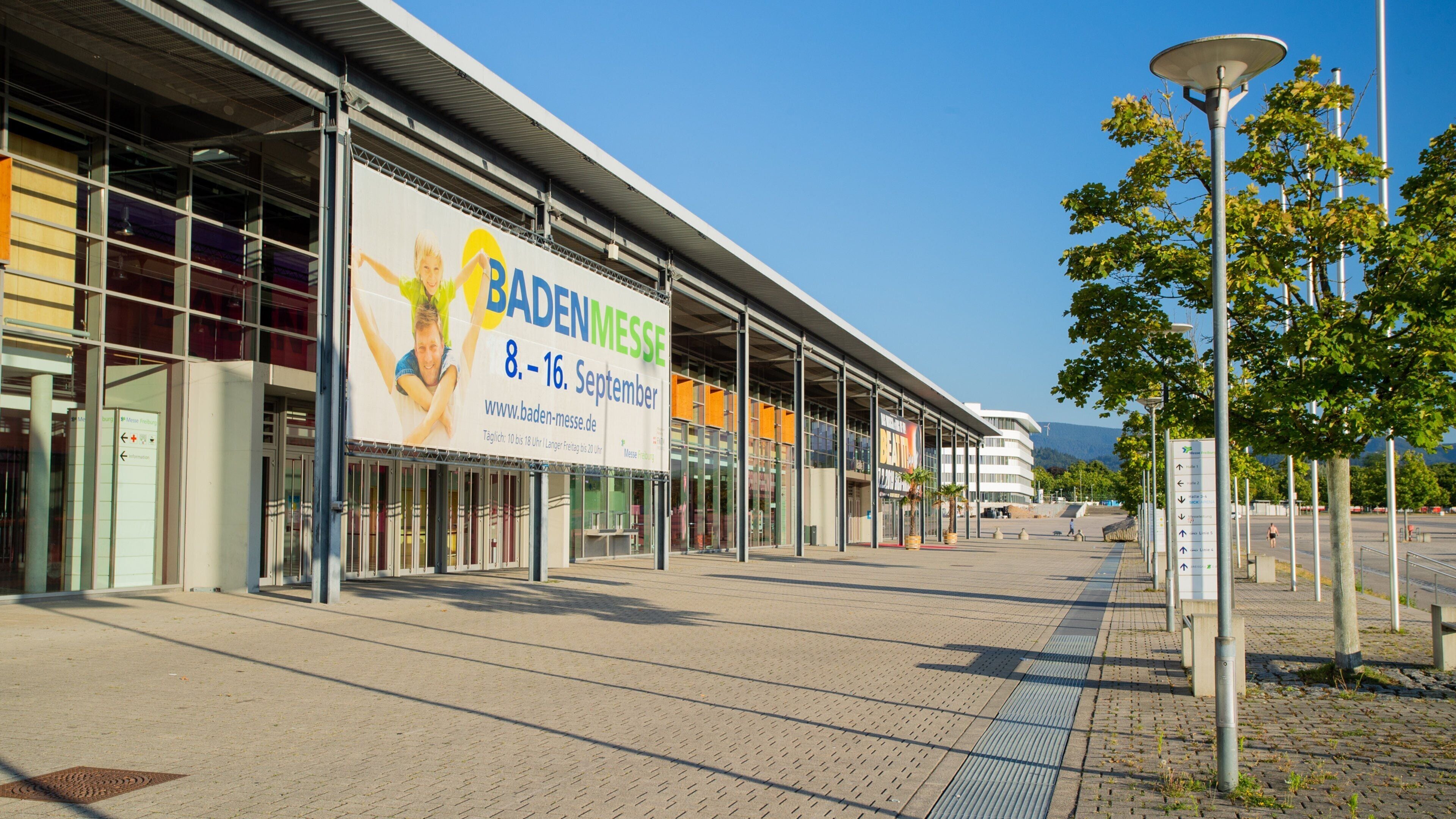 A modern building with a large billboard advertising an event from 8-16 September.